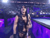 a female wrestler is holding a trophy in a wrestling ring