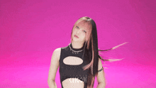 a woman with pink hair is wearing a black top with a hole in the middle