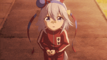 a little girl wearing a red and white tracksuit with the letter t on the sleeve