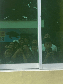 a group of people are taking a selfie in front of a sign that says 2 я