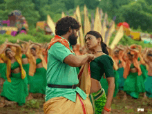 a man in a green shirt is adjusting a woman 's green blouse