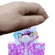 a person is putting their hand on top of a stuffed animal .