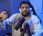 a man wearing headphones is sitting in front of a microphone with the name smhashloy on the bottom right