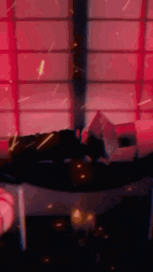 a person is laying on a bed in front of a window with a red light coming out of it .