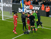 a group of soccer players are standing on a field with a sign that says betway in the background .