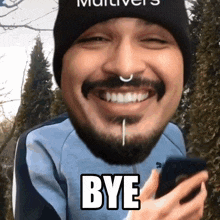 a man with a beard and a nose ring is smiling and holding a cell phone with the word bye above his head