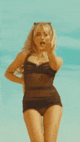 a woman in a pink swimsuit and sunglasses is laying on her back