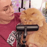 a woman wearing a red shirt with the word angry on it holds a cat