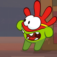 a green and red cartoon character with a yellow ribbon around his neck