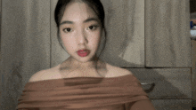 a woman wearing a brown off the shoulder top