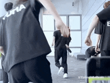 a group of people are holding hands in a room .