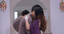 a man and a woman are kissing in front of a mirror in a room .