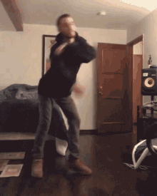 a man is dancing in a living room in front of a speaker that has the letter s on it