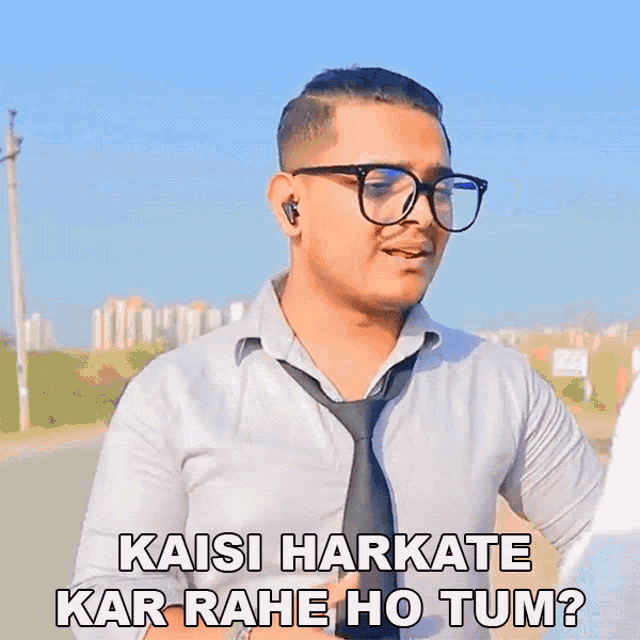 a man wearing glasses and a tie says 