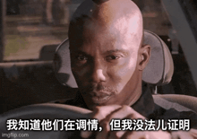 a bald man is driving a car with chinese writing on the side