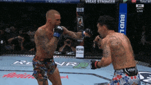 two men are fighting in a boxing ring with a bud light banner in the background