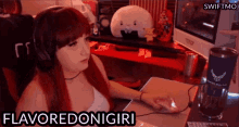 a woman wearing headphones is sitting at a desk with a computer mouse and says flavoredonigiri