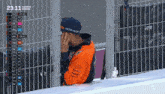 a man wearing a blue hat that says factory racing covering his face