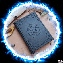 a book with a pentagram on it is surrounded by a blue lightning circle