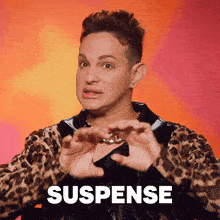 a man in a leopard print jacket is making a gesture with his hands and the word suspense is behind him