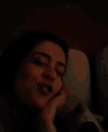 a woman is smiling while laying in bed with a stuffed animal
