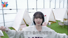 a girl wearing headphones is standing in front of tents and a sign that says nz trip