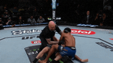 a referee in a ufc ring with a tequila banner