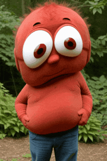 a red cartoon character with big eyes is standing in the woods