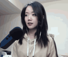 a woman wearing headphones and a microphone looks at the camera