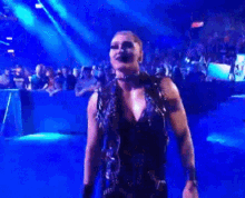 a woman in a black dress is standing in front of a crowd .