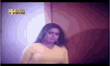 a woman in a yellow top is standing in front of a cd plus logo
