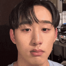a close up of a young man 's face with a blue shirt on