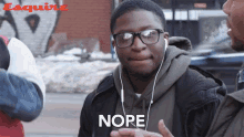 a man wearing headphones says nope in front of esquire