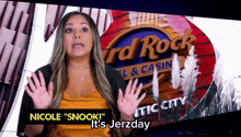 a woman in front of a hard rock sign