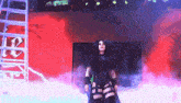 a woman in a black outfit stands in front of a sign that says rb