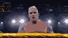 a man in a boxing ring with the words #wwe nxt on the bottom