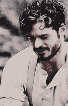 a man with a beard and curly hair is wearing suspenders