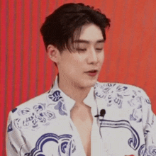 a close up of a young man wearing a shirt with a microphone on his neck .
