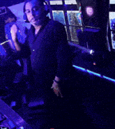 a man wearing headphones is dancing in front of a machine that has the letter l on it
