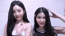 two girls with long black hair are standing next to each other and smiling
