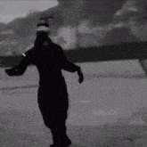 a black and white photo of a man wearing a mask dancing on ice .