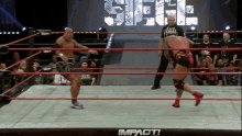 two wrestlers in a wrestling ring with the word impact on the mat