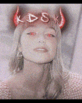 a woman wearing a hat with red horns and the letters kdsx on it