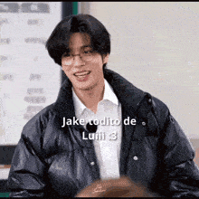 a young man wearing glasses and a black jacket says " jake todito de luiii "