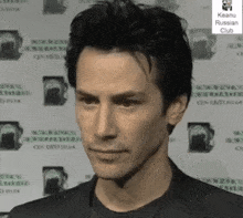a man is standing in front of a wall that says keanu russian