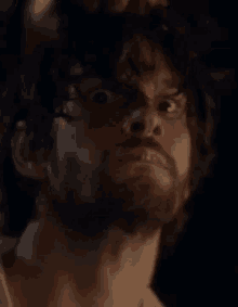 a close up of a man 's face with a beard making a funny face