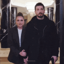 a man and a woman are holding hands in front of a door