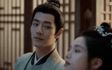 a man and a woman are looking at each other in a room .