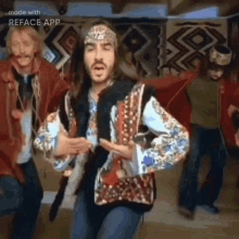 a man with long hair and a beard is dancing with other men .