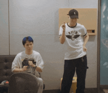 a man wearing a shirt that says buco is standing next to another man